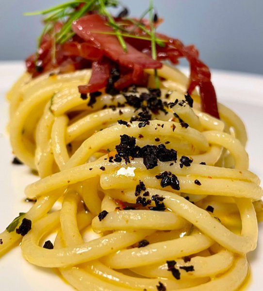 Spaghetti aglio, olio, peperoncino, polvere di olive nere e speck croccante