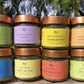 8 aromi in barattolo di vetro con etichette colorate e tappi color rame su tavolo di legno con sfondo naturale